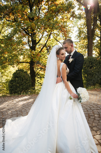 Newlyweds are walking in the park. Wedding couple in autumn