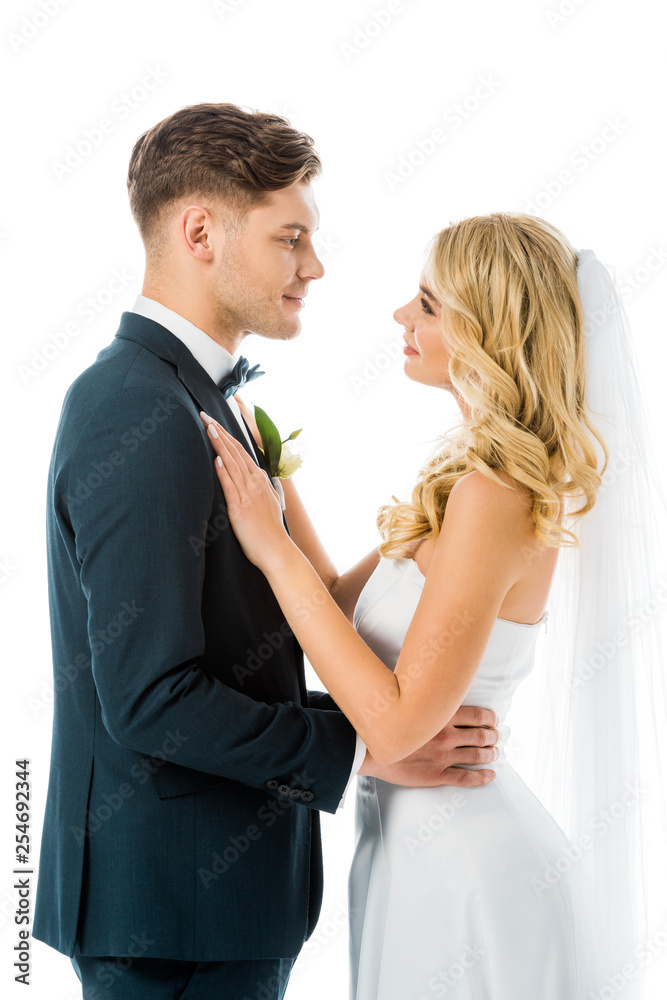 happy young bride and groom hugging and looking at each other isolated on white happy young bride and groom hugging and looking at each other isolated on white