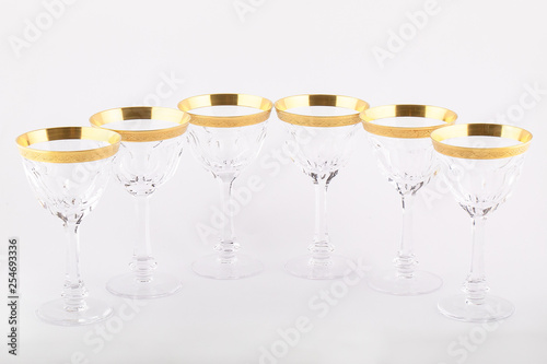 Stemware faceted glasses made of Czech glass with a Golden ornament isolated on a white background.
