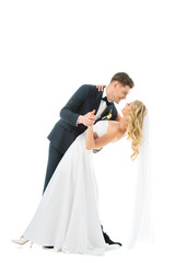 handsome groom in elegant suit dancing with beautiful bride in wedding dress isolated on white