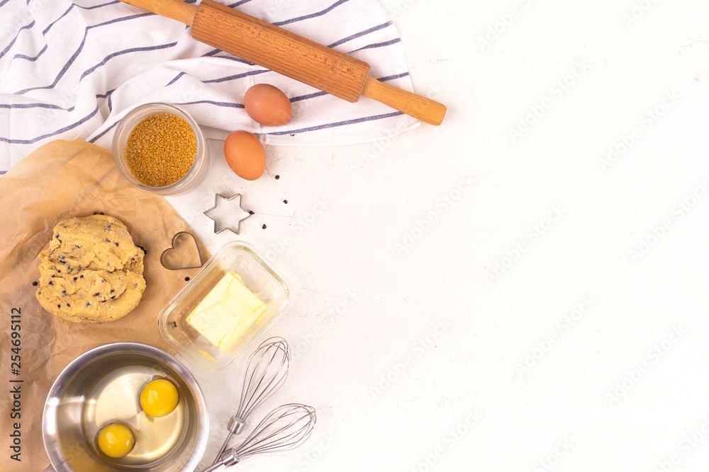 Culinary equipment and ingredients. Eggs, flour, sugar, chocolate, butter, bakeware. Flat lay. Copy space.