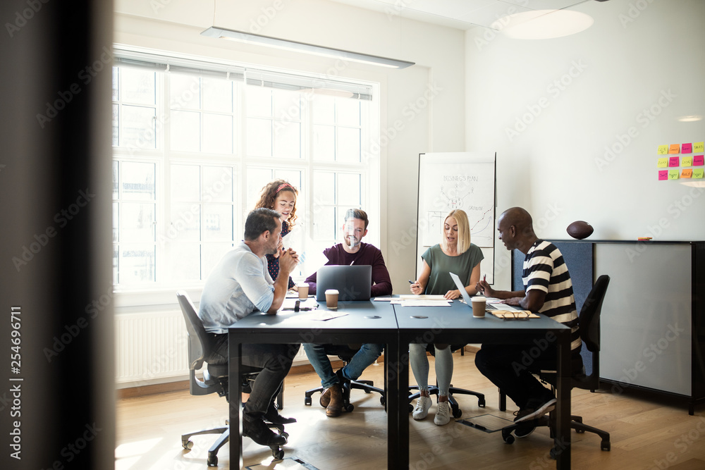 Designers discussing work during a meeting in an office Designers discussing work during a meeting in an office