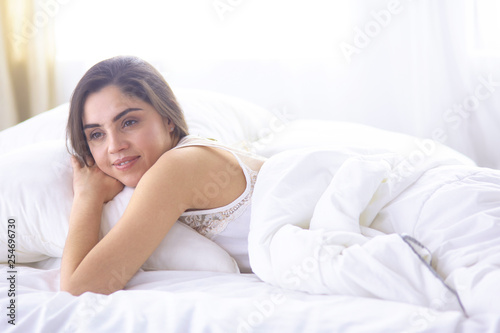 beautiful young woman basking in bed in the morning. Beautiful Model face looks sexy in camera