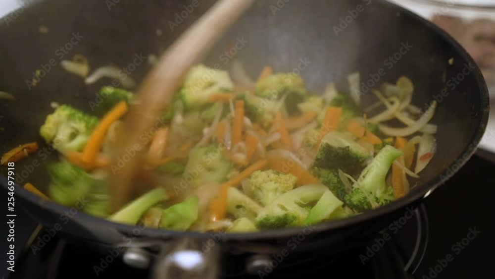 Mixed vegetables fried in pan , smoke from frying 