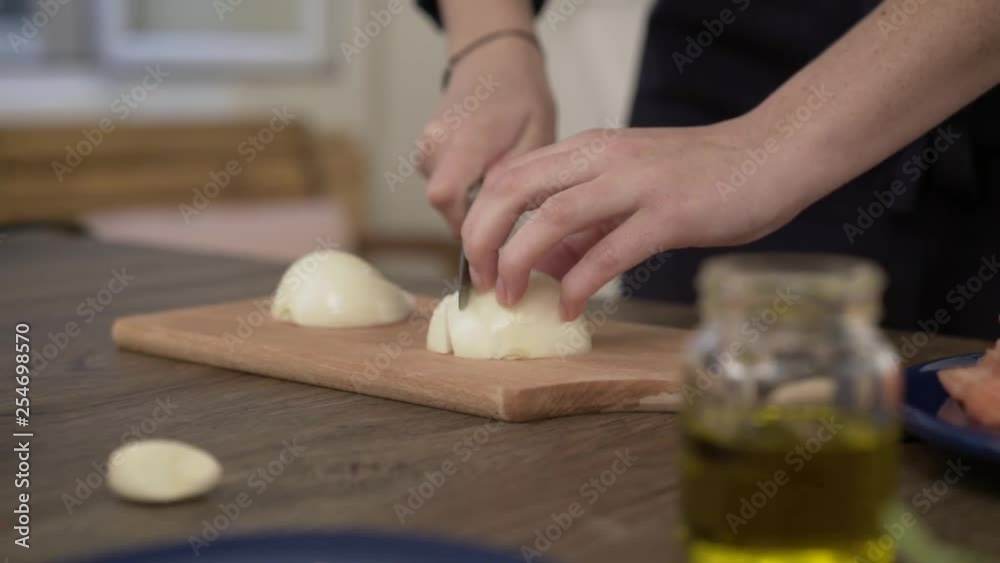 Chopping onion on a wooden cutting board Chopping onion on a wooden cutting board