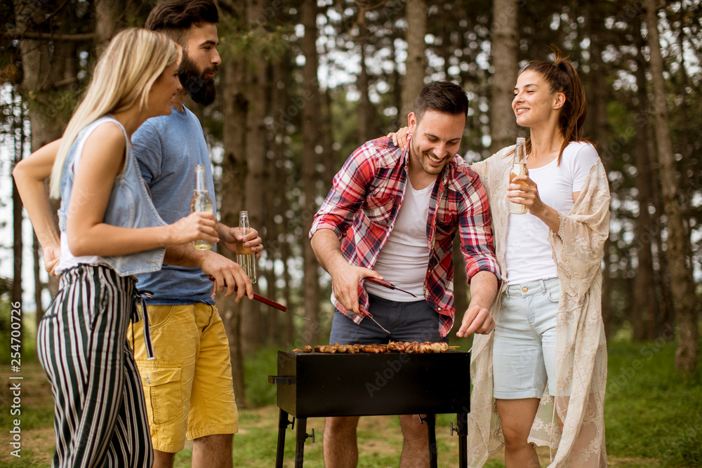 Naklejka premium Group of young people enjoying barbecue party in the nature