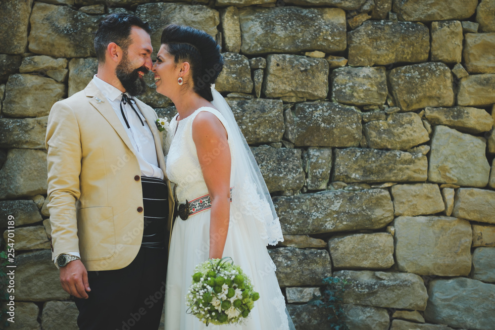 bride and groom kissing in front of stone wall bride and groom kissing in front of stone wall