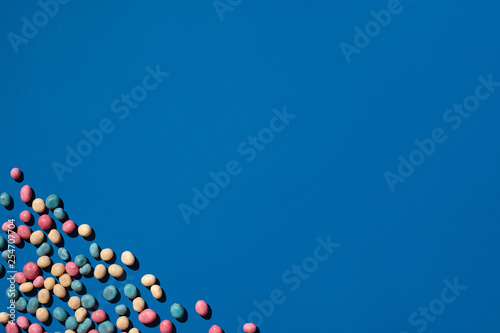 Photo of candies dragee placed on the corner of image with a copy space in the middle