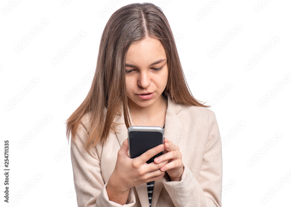Portrait of beautiful Teen Girl talk to Mobile Phone, isolated on white background. Smiling Child standing and using Cell Phone. Pretty modern Teenager wearing an jacket with Smartphone.