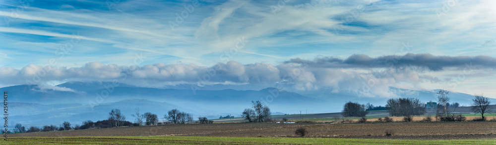 Panorama, hanging clouds over a mountain range.