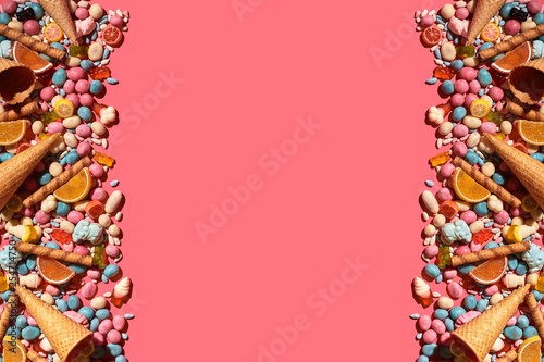 Various sweets  candys are palced on the photo on the coral background