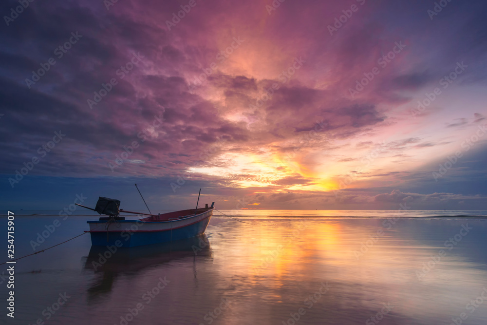Boat on the sea with  reflection in the water at sunrise