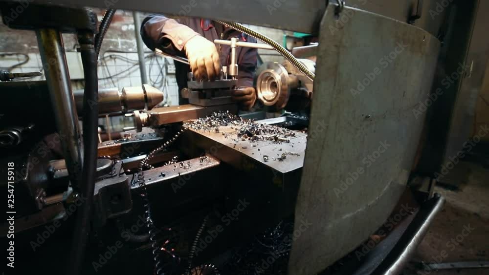 Industrial concept. Construction plant. A man worker tighten the nuts on a lathe Industrial concept. Construction plant. A man worker tighten the nuts on a lathe
