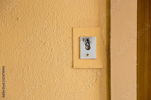 Old elevator call button with grungy pattern in a soviet building in post-soviet Riga, Latvia