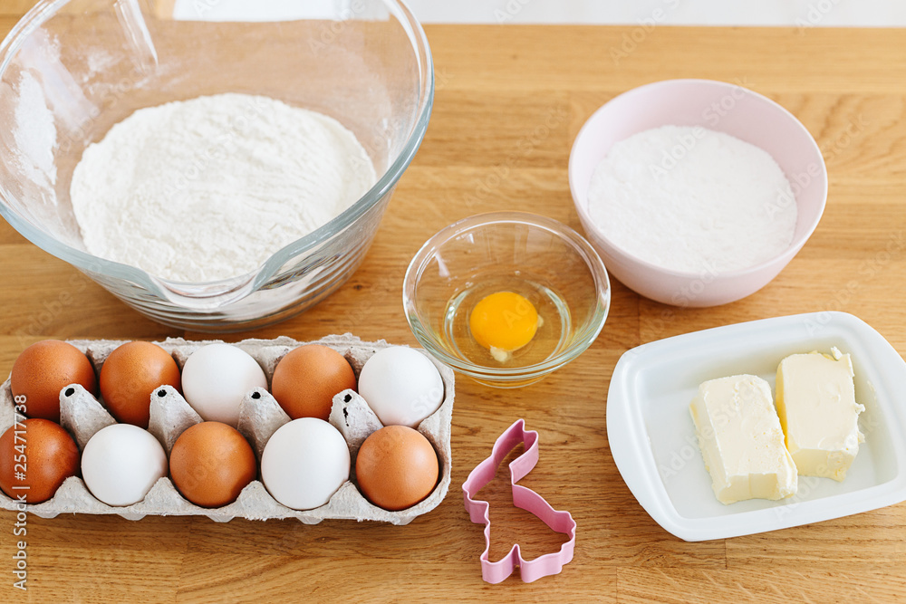 Baking ingredients placed on wooden table, ready for cooking. Concept of food preparation, white kitchen on background. Baking ingredients placed on wooden table, ready for cooking. Concept of food preparation, white kitchen on background.