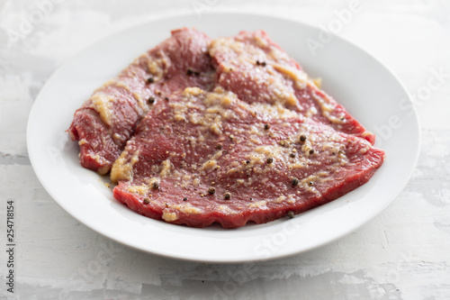 raw meat with spices on white dish