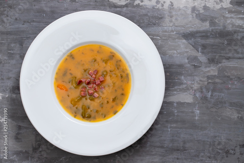 soup with smoked meat in white plate on ceramic dish