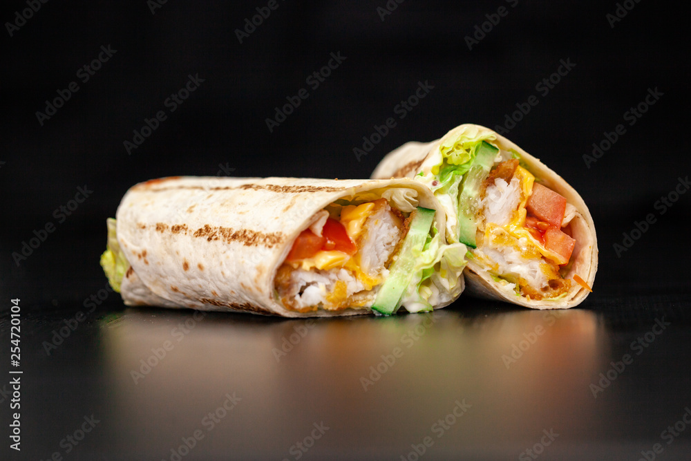 Shawarma sandwich gyro- fresh roll of thin lavash (pita bread) filled with grilled meat, mushrooms, cheese, cabbage, carrots, sauce, green. Traditional Eastern snack. On a wooden background Shawarma sandwich gyro- fresh roll of thin lavash (pita bread) filled with grilled meat, mushrooms, cheese, cabbage, carrots, sauce, green. Traditional Eastern snack. On a wooden background