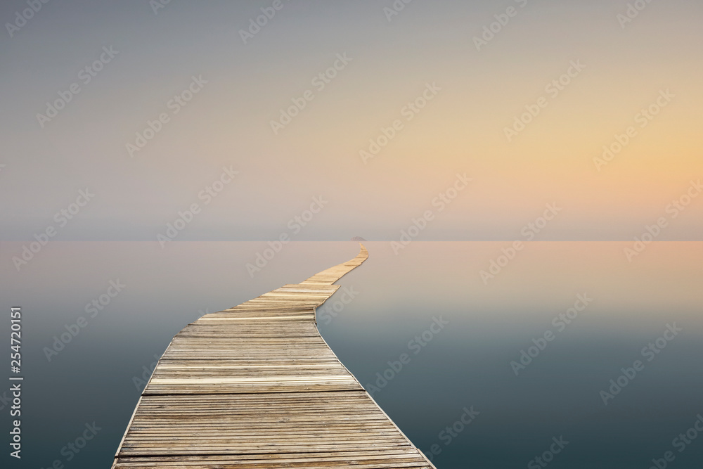 landscape with calm sea and long wharf at sunset