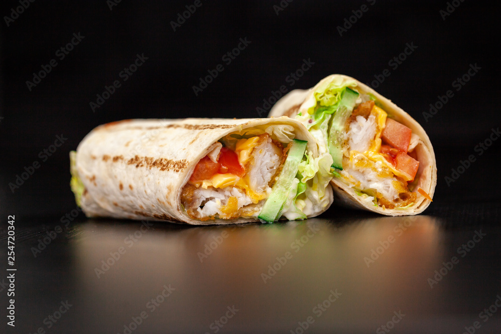 Shawarma sandwich gyro- fresh roll of thin lavash (pita bread) filled with grilled meat, mushrooms, cheese, cabbage, carrots, sauce, green. Traditional Eastern snack. On a wooden background Shawarma sandwich gyro- fresh roll of thin lavash (pita bread) filled with grilled meat, mushrooms, cheese, cabbage, carrots, sauce, green. Traditional Eastern snack. On a wooden background