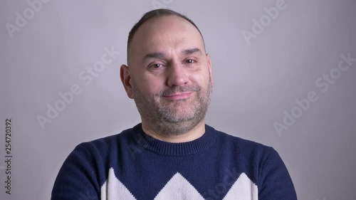 Closeup shoot of adult caucasian bearded man smiling and nodding his head in token of agreement
