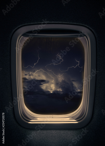 night thunderstorm with lightning seen from window airplane.