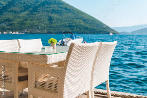 cafe table on beach with beautiful view of sea and mountains © phpetrunina14