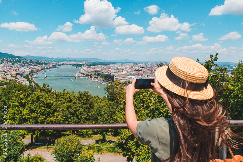 Fototapeta premium young woman taking picture with smartphone of old european city