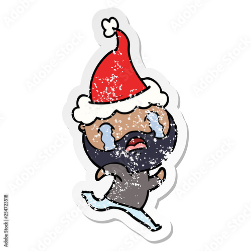 distressed sticker cartoon of a bearded man crying wearing santa hat