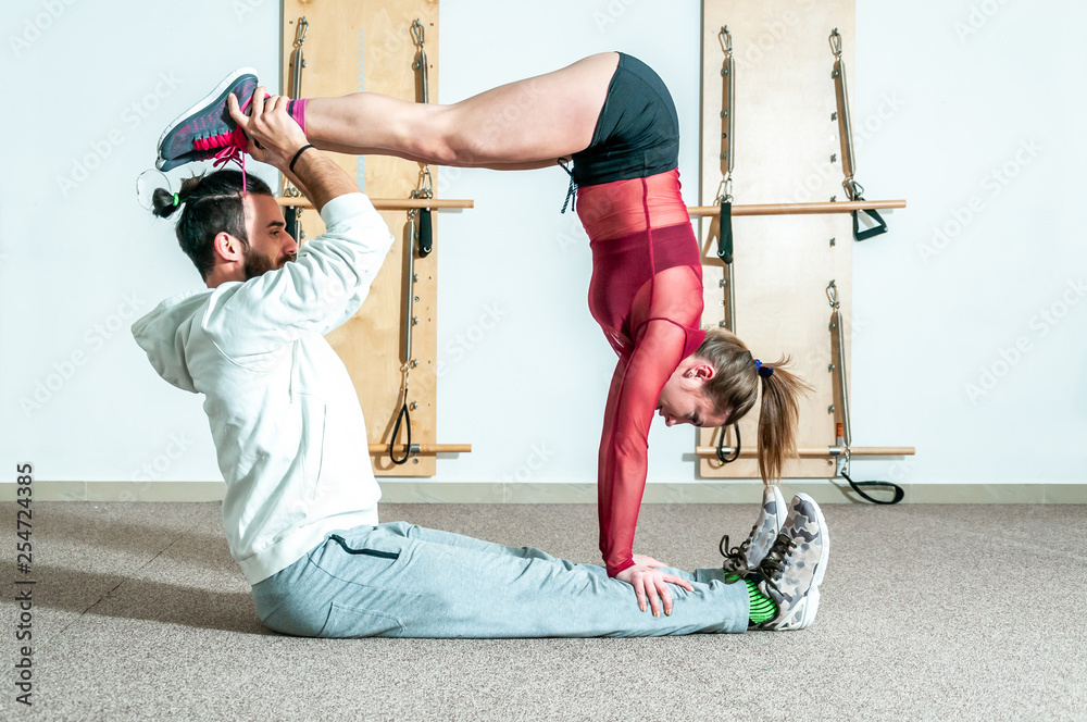 Yoga couple, Young healthy yoga fitness acrobatic couple having fun in the  gym performing and practicing funny acrobat poses real people training  workout Stock Photo