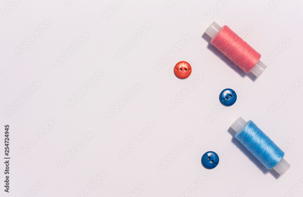 sewing thread with buttons, delicate colors, on white surface.copy space sewing thread with buttons, delicate colors, on white surface.copy space
