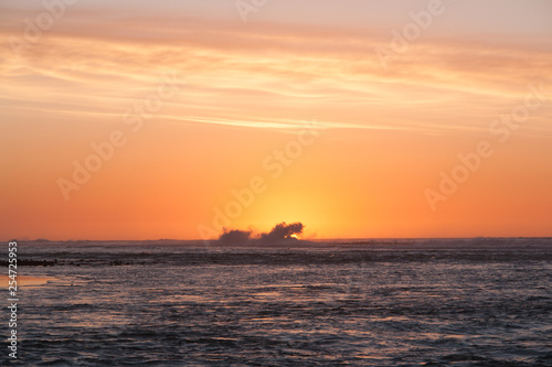 Sea sunset. Waves devour the last rays of the sun.