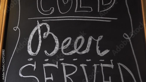 Craft cold beer served here insctiption by white chalk on black board. Invitation to brewery bar pub for drinking craft beer. Beer menu in bar pub. photo