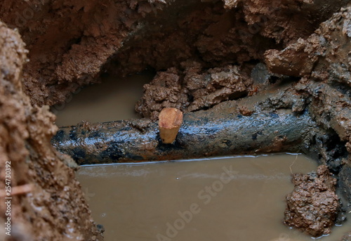 Wooden wedge in craced pipe photo