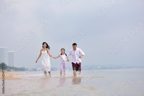 happy family of father, mother and daughter on the beach .Concept for  family holiday ,vacation ,insurance and summer.