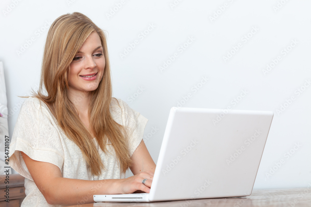 Young woman using a notebook computer indoors Young woman using a notebook computer indoors