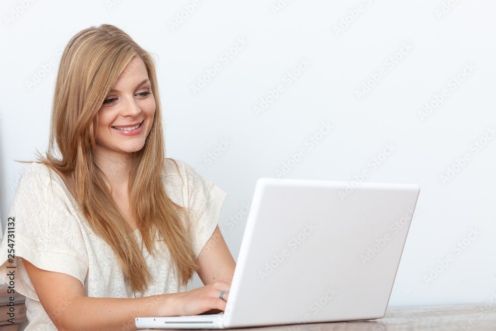 Young woman using a notebook computer indoors Young woman using a notebook computer indoors