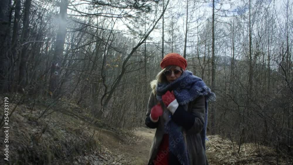 Young attractive woman with red hat wanders in forest Young attractive woman with red hat wanders in forest