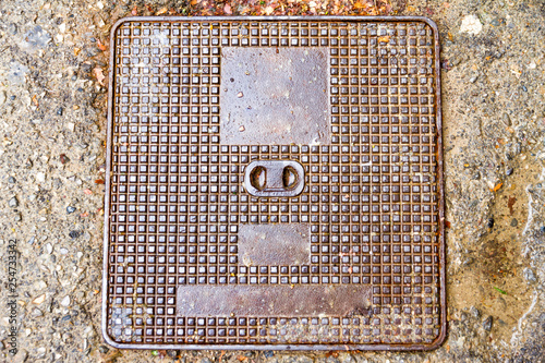 Square manhole with no writings or signs in a wet day