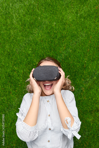 Young woman having VR experience on grass