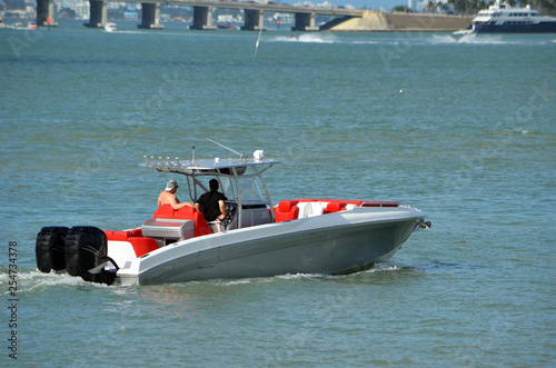 Silver sport fishing boat ;powered by three outboard engines