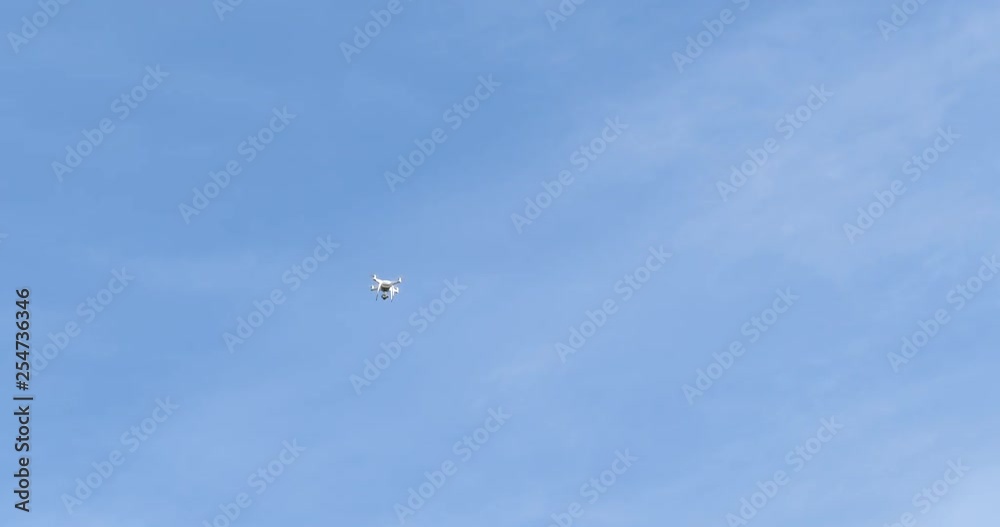 Technology Concept White Quadcopter Drone in the Air Flying in Strong Wind Blue Sky Technology Concept White Quadcopter Drone in the Air Flying in Strong Wind Blue Sky