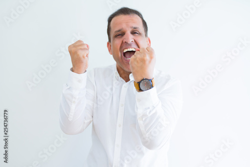 Middle age man celebrating and screaming happy for succesful win