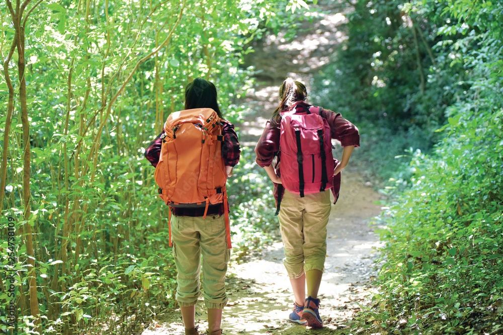 Side view of Two young Asian female hipster hiking in deep forest holiday, wild adventure. Background for Travel concept Side view of Two young Asian female hipster hiking in deep forest holiday, wild adventure. Background for Travel concept