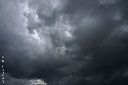 Dark, grim, stormy, rainy sky with rays of light. Scary hurricane clouds. Natural element. Stock Photo for your design