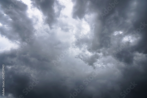 Dark, grim, stormy, rainy sky with rays of light. Scary hurricane clouds. Natural element. Stock Photo for your design