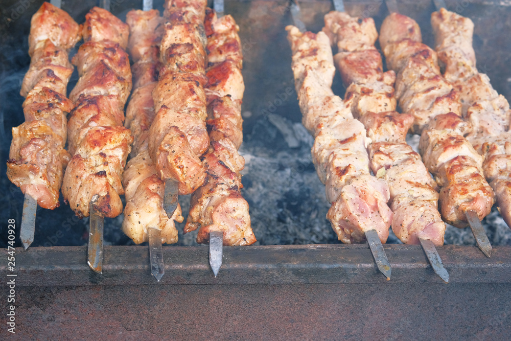 BBQ outdoor during summer time. Shish kebab national cuisine of Central Asia and middle East. Festival outdoor. Cooking meat on barbecue.