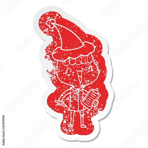 cartoon distressed sticker of a happy boy surprised wearing santa hat