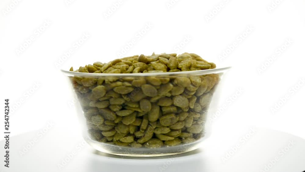 Glass bowl full of soya beans rotating set against white isolated studio background. Glass bowl full of soya beans rotating set against white isolated studio background.