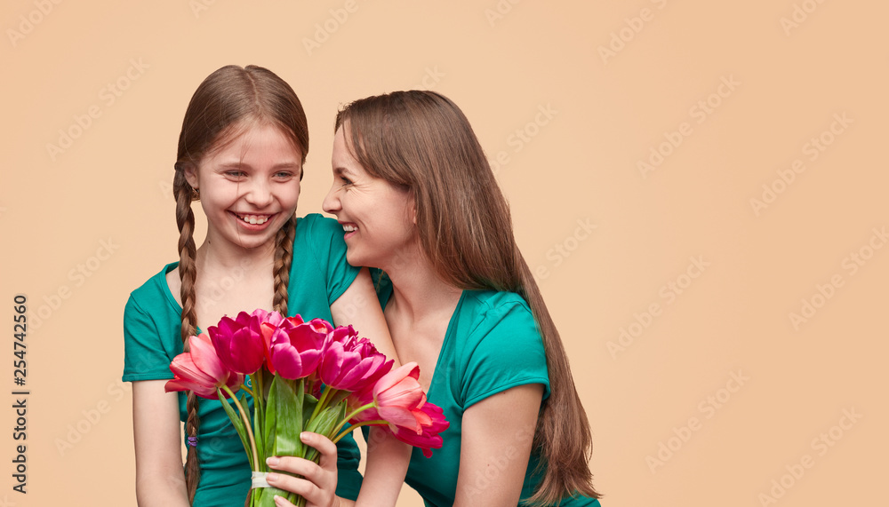 Happy woman and girl with bunch of flowers Happy woman and girl with bunch of flowers